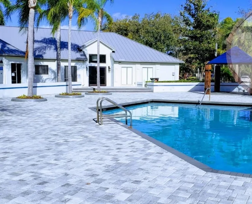 Completed light colored paver deck beside a Florida swimming pool