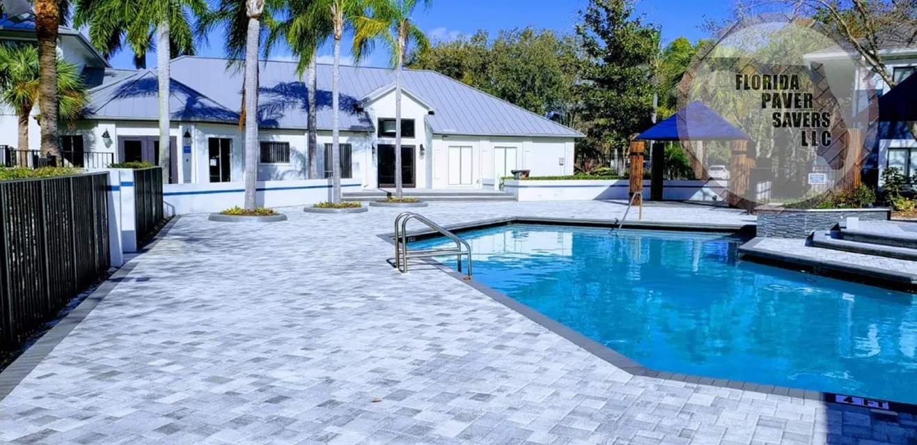 Florida Paver Savers pool deck with pale stone pavers, blue water and palm trees
